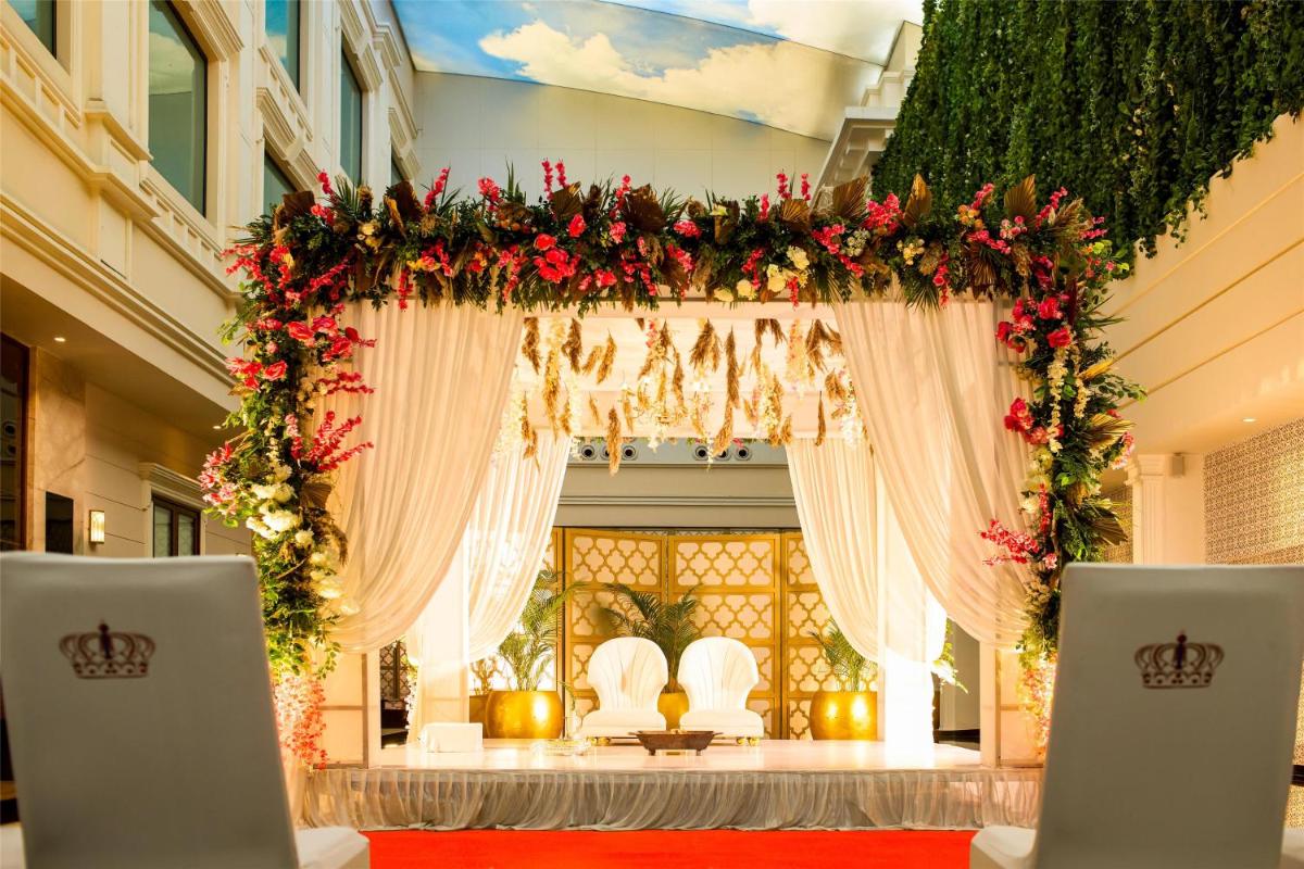 a wedding arch with flowers and greenery at Radisson Blu Hotel & Suites GRT Chennai in Chennai