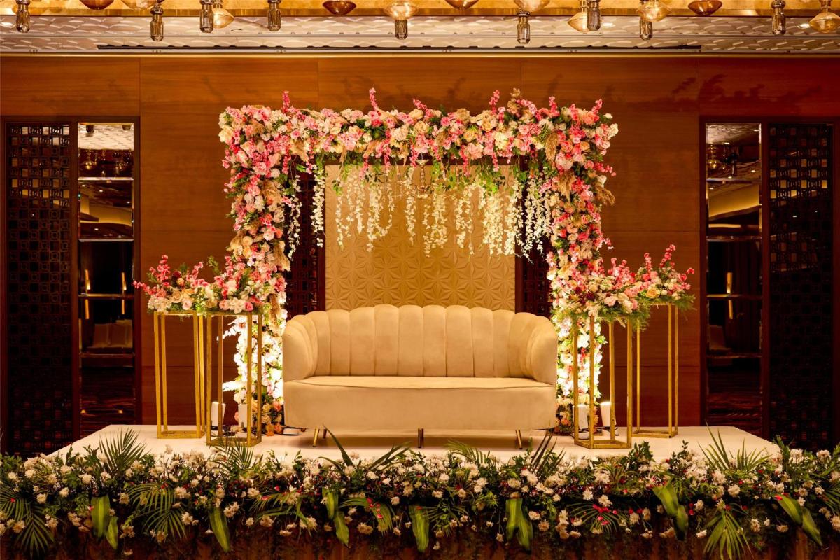 an altar with a white couch in a room with flowers at Radisson Blu Hotel & Suites GRT Chennai in Chennai