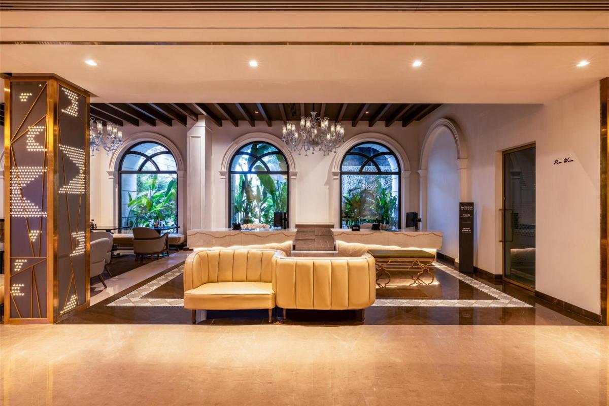 a living room with couches and a chandelier at Radisson Blu Hotel & Suites GRT Chennai in Chennai
