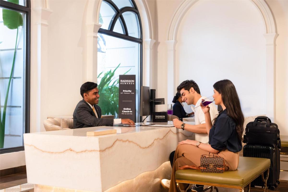 a group of people sitting at a desk in a room at Radisson Blu Hotel & Suites GRT Chennai in Chennai