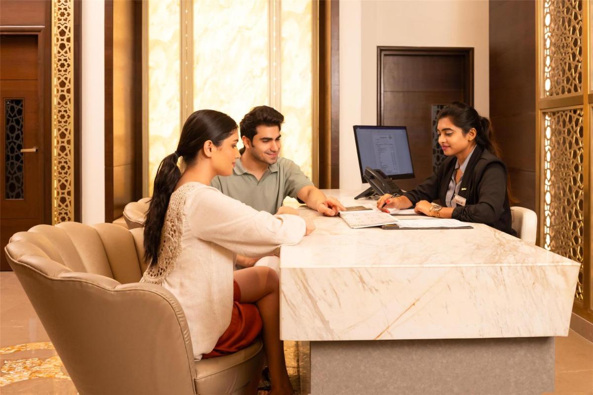 a group of people sitting at a table with a computer at Radisson Blu Hotel & Suites GRT Chennai in Chennai