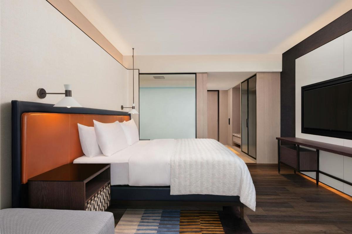 a hotel room with a bed and a flat screen tv at Le Meridien Ahmedabad in Ahmedabad