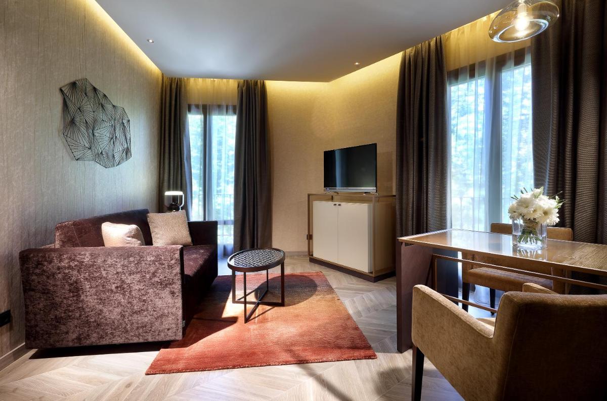 Una sala de estar con un sofá y un televisor. en Áurea Washington Irving by Eurostars Hotel Company, en Granada