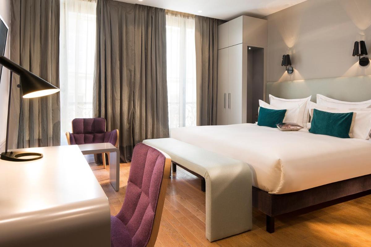 une chambre d'hôtel avec un lit et une chaise dans l'établissement Monsieur Cadet Hotel & Spa, à Paris