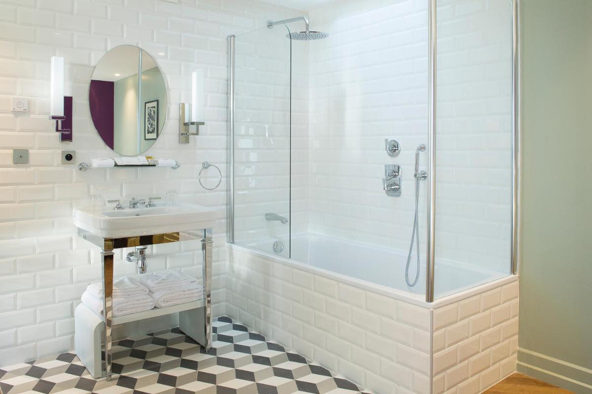 une salle de bain blanche avec une douche et un lavabo dans l'établissement Monsieur Cadet Hotel & Spa, à Paris