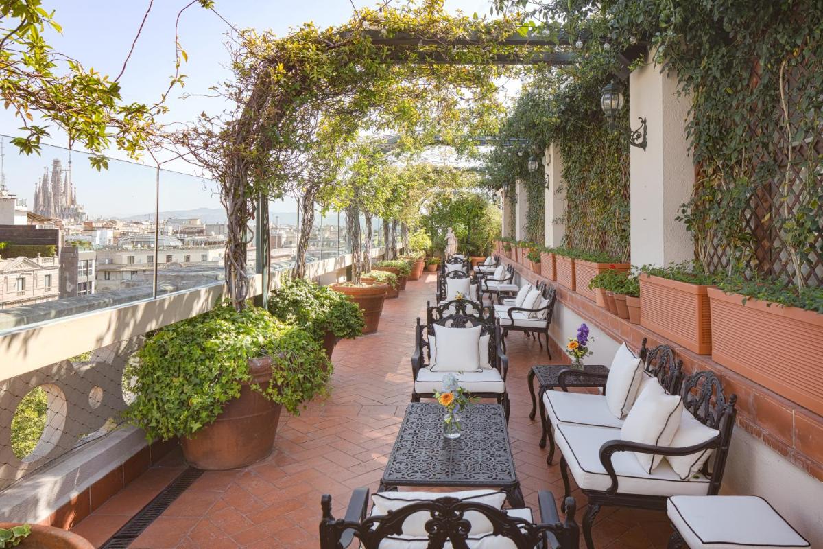 una fila de mesas en un balcón con plantas en Hotel El Palace Barcelona, en Barcelona
