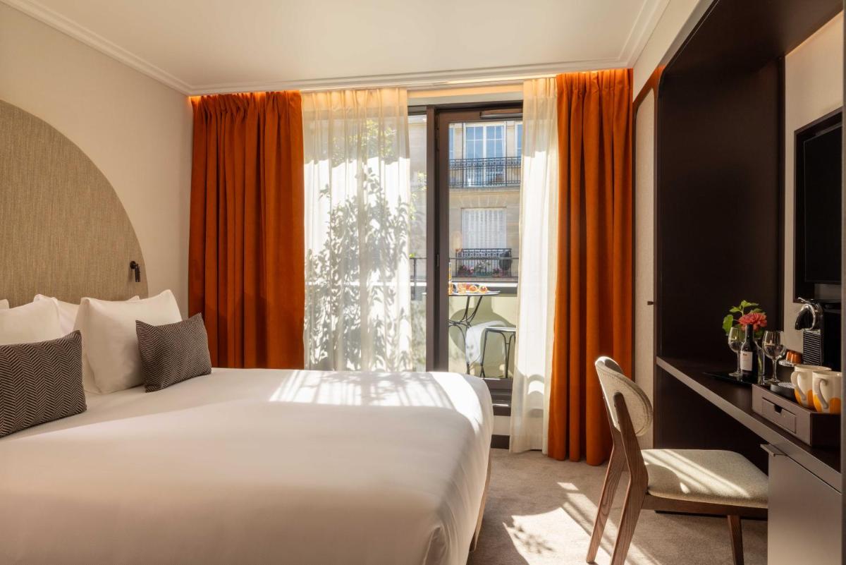une chambre d'hôtel avec un lit et une fenêtre dans l'établissement Belinda Hôtel & Spa, à Paris