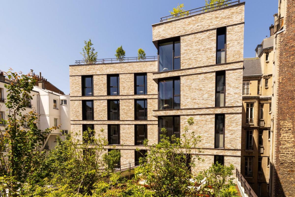 - un bâtiment en briques avec des fenêtres sur le côté dans l'établissement Belinda Hôtel & Spa, à Paris