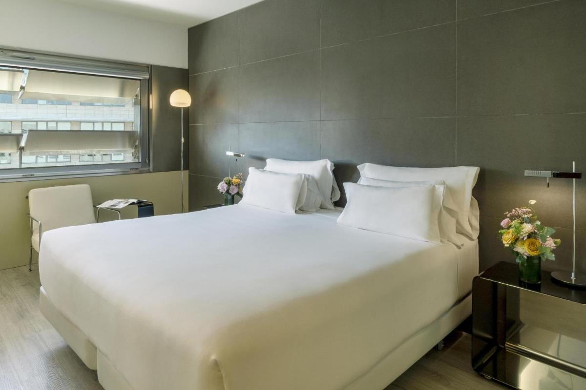 Una cama blanca grande en una habitación con ventana. en NH Collection Barcelona Constanza, en Barcelona