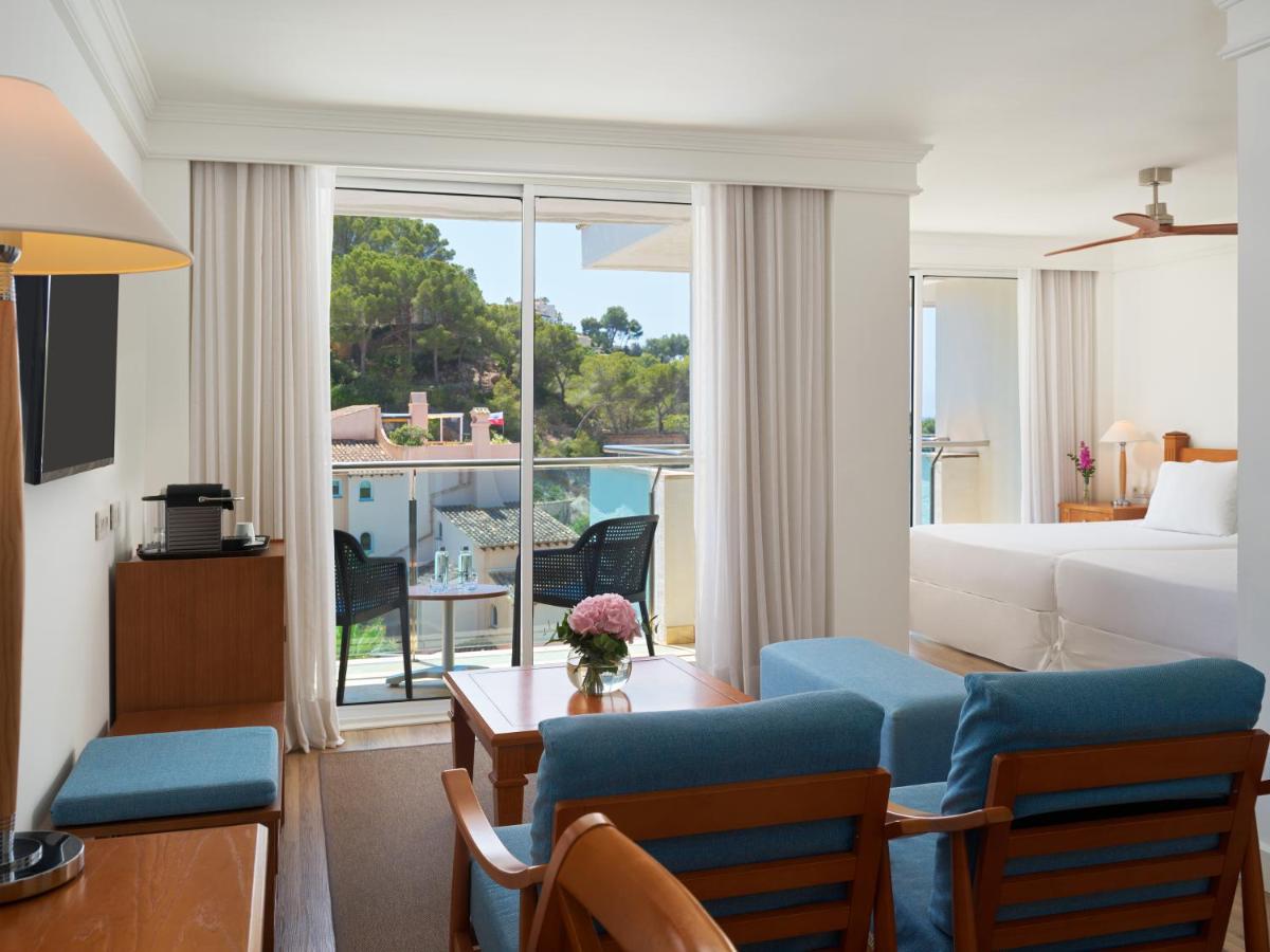 Una habitación de hotel con una cama y una sala de estar. en Boutique Hotel H10 Blue Mar - Adults Only, en Camp de Mar