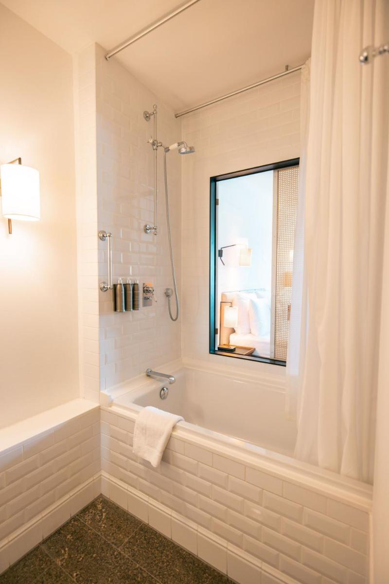 ein Badezimmer mit Badewanne und Fenster in der Unterkunft Louis Hotel in München + 27 Fotos ein Badezimmer mit Badewanne und Fenster in der Unterkunft Louis Hotel in München + 27 Fotos