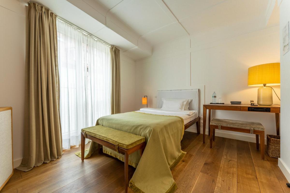 ein Schlafzimmer mit einem Bett, einem Schreibtisch und einem Fenster in der Unterkunft Louis Hotel in München ein Schlafzimmer mit einem Bett, einem Schreibtisch und einem Fenster in der Unterkunft Louis Hotel in München