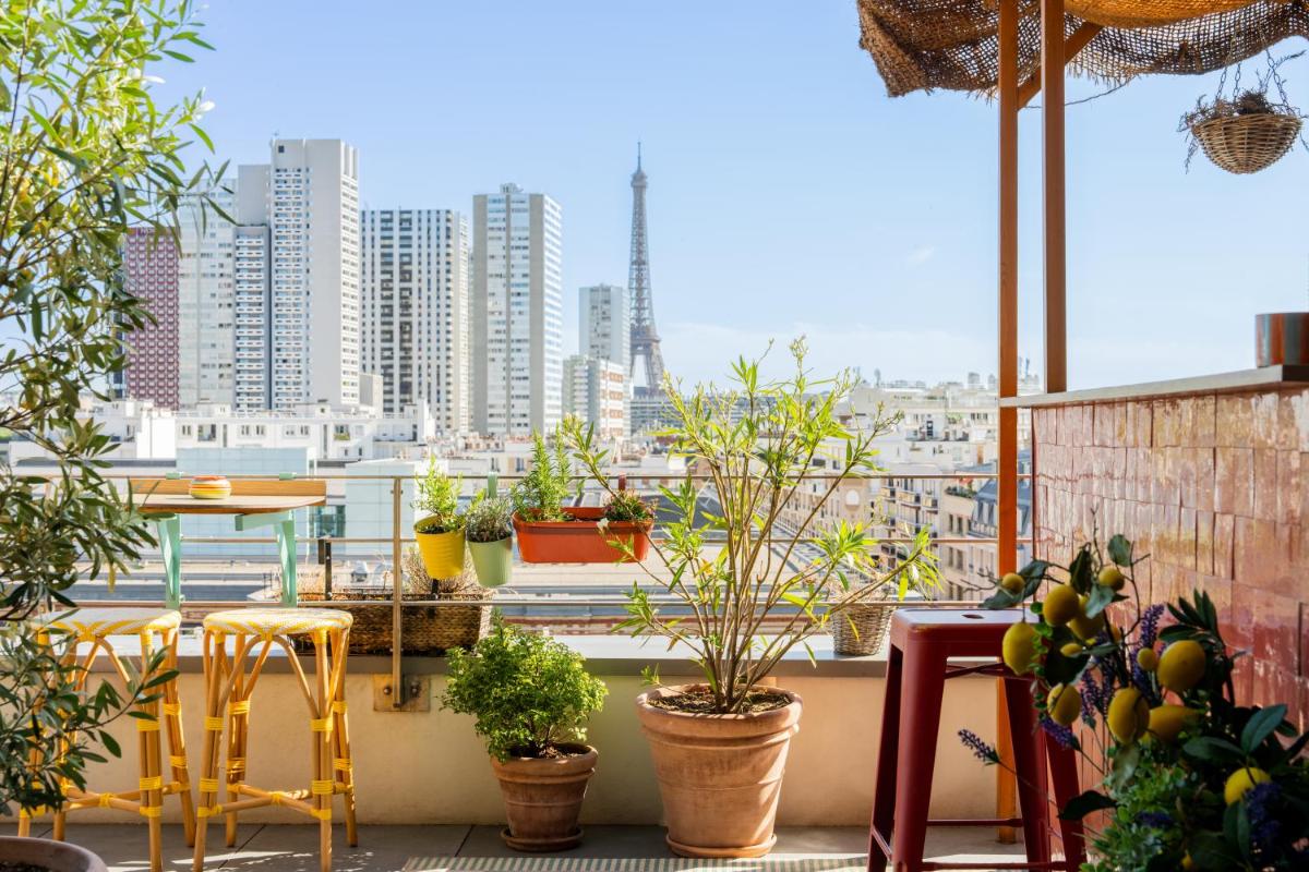 un balcon avec des plantes en pot et une vue sur une ville dans l'établissement Quinzerie hôtel, à Paris