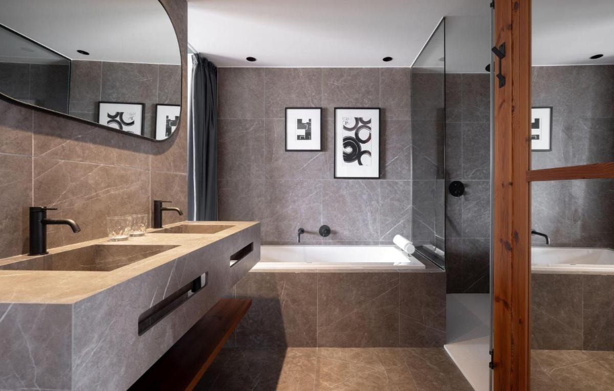 Un baño con dos lavabos, una bañera y una ducha. en Hotel Aubamar Suites & Spa, en Playa de Palma