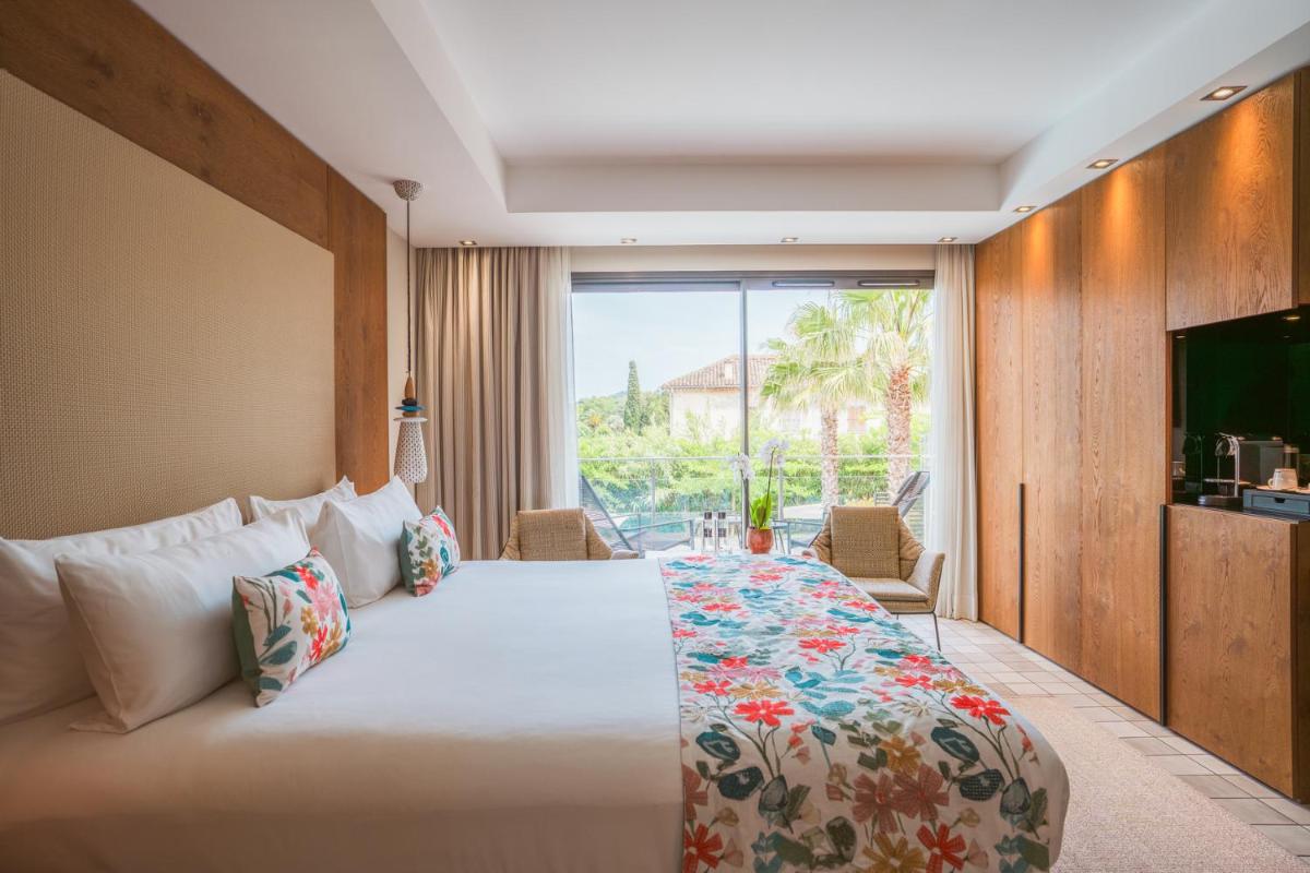 une chambre avec un grand lit et une grande fenêtre dans l'établissement Kube Saint-Tropez, à Saint-Tropez