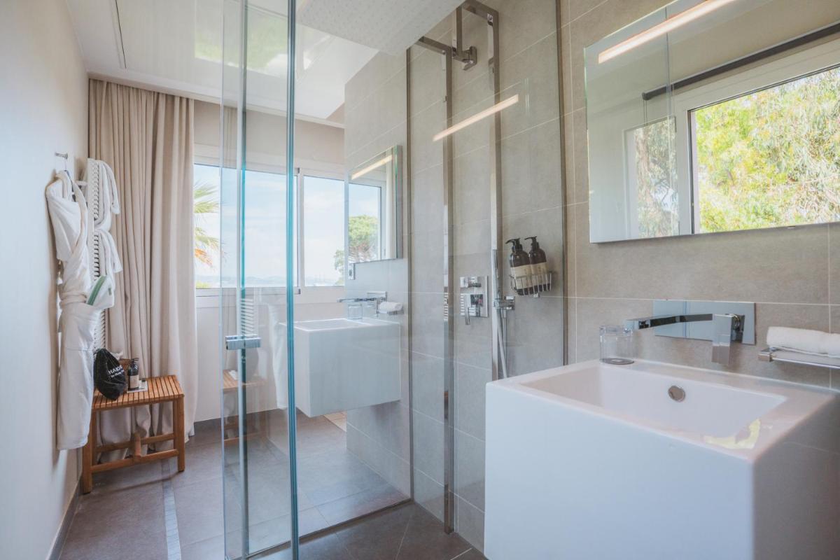 une salle de bains avec lavabo et douche en verre dans l'établissement Kube Saint-Tropez, à Saint-Tropez