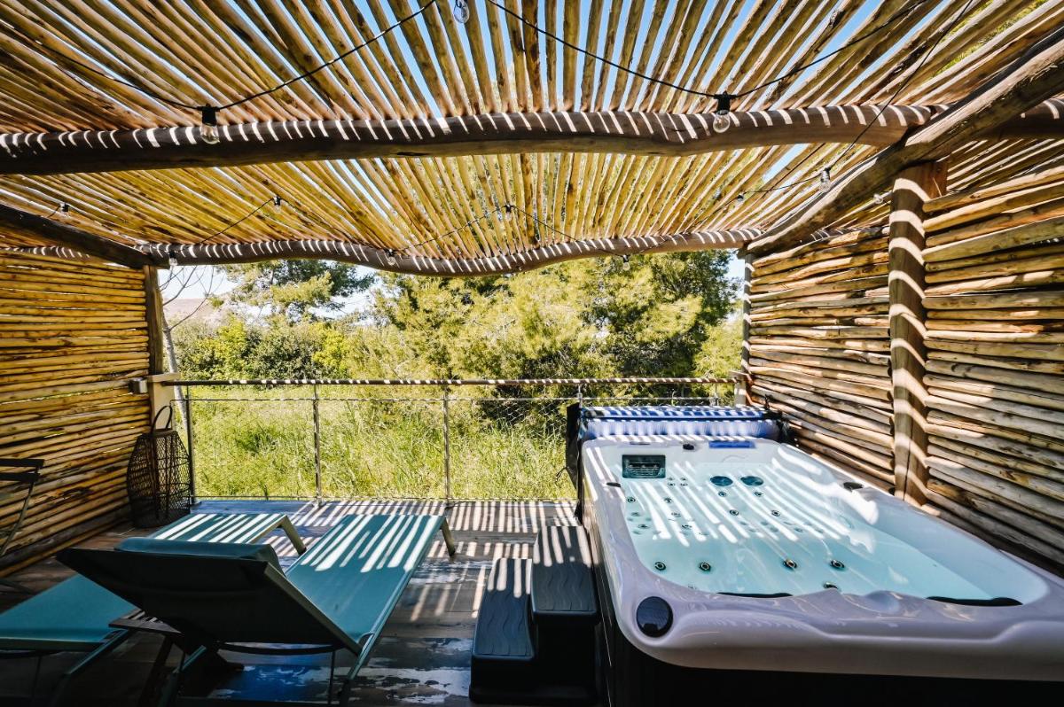 une pergola avec un lit, une table et une chaise dans l'établissement Le Hameau Des Pesquiers Ecolodge & Spa, Curio Collection By Hilton, à Hyères 146 autres photos