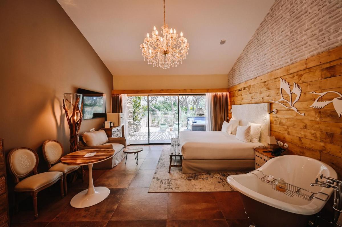 une chambre d'hôtel avec un lit et une salle de bain dans l'établissement Le Hameau Des Pesquiers Ecolodge & Spa, Curio Collection By Hilton, à Hyères