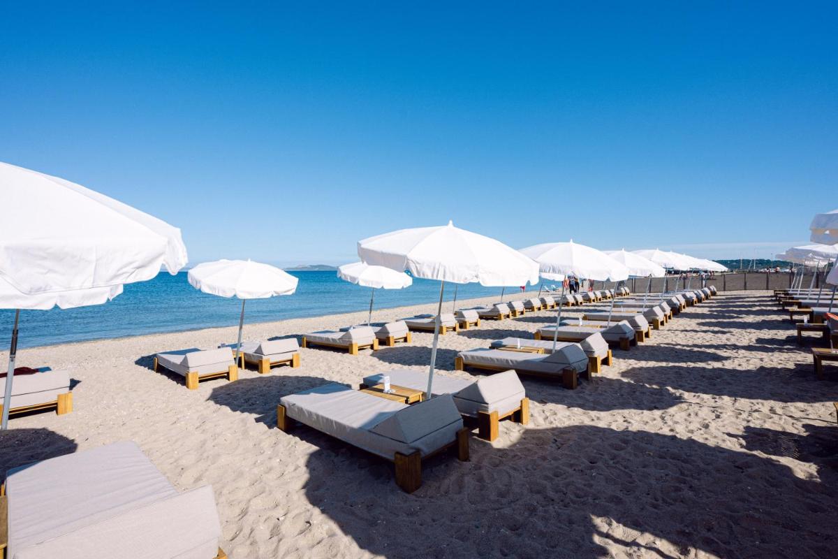 - une rangée de parasols et de chaises sur une plage dans l'établissement Le Hameau Des Pesquiers Ecolodge & Spa, Curio Collection By Hilton, à Hyères