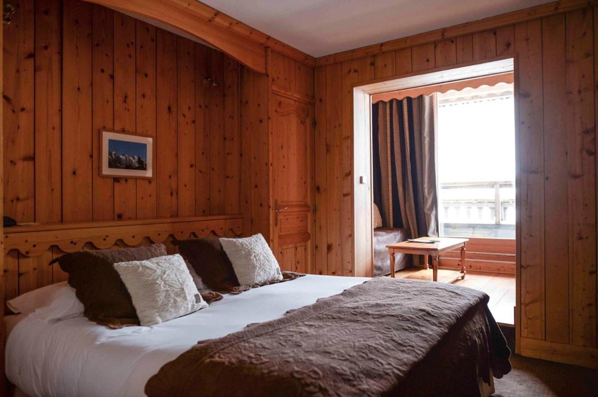 une chambre avec un grand lit et une fenêtre dans l'établissement Hôtel Le Jeu de Paume, à Chamonix-Mont-Blanc