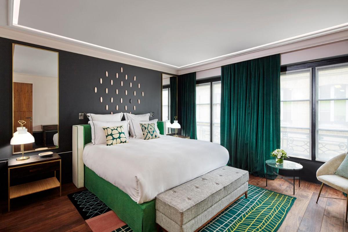 - une chambre avec un grand lit et des rideaux verts dans l'établissement Le Roch Hotel & Spa, à Paris