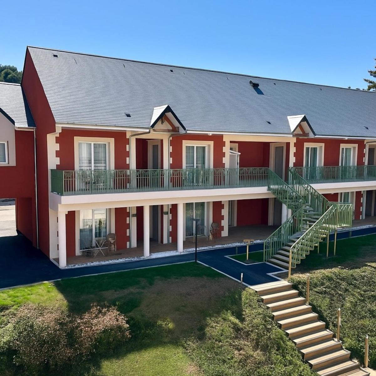 vue antérieure d'un grand bâtiment rouge avec des escaliers dans l'établissement Tulip Inn Honfleur Residence & Spa, à Honfleur