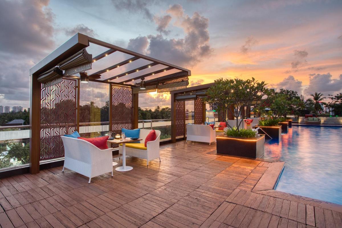 a patio with a table and chairs next to a pool at Holiday Inn Cochin by IHG in Cochin a patio with a table and chairs next to a pool at Holiday Inn Cochin by IHG in Cochin