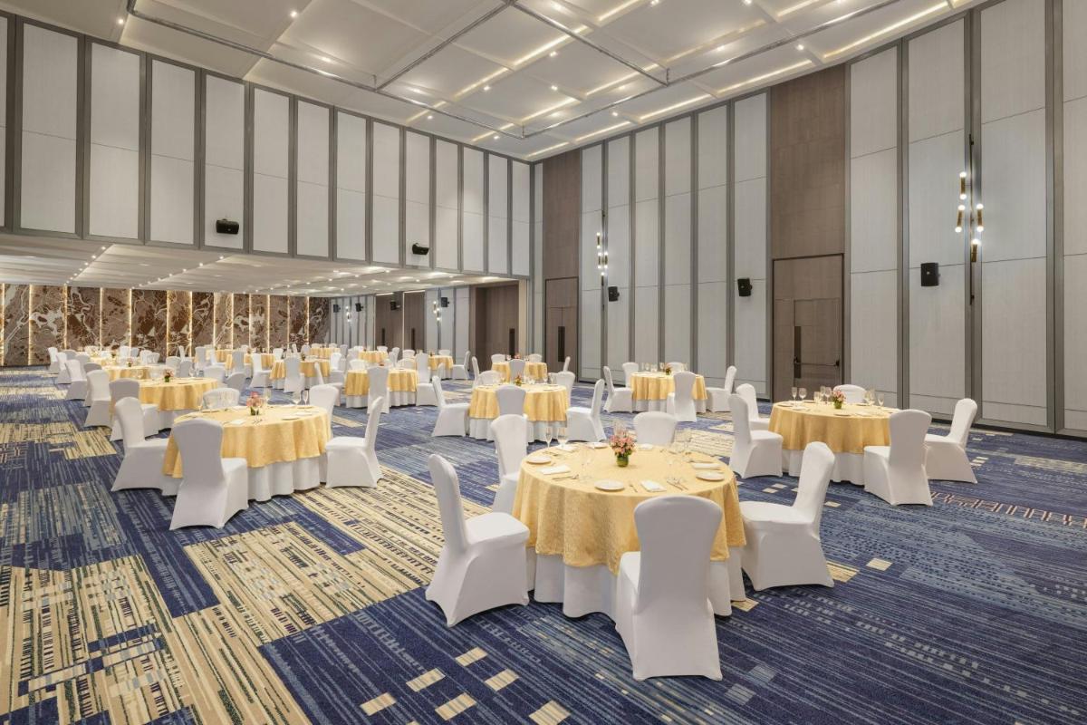 a banquet hall with white tables and white chairs at Le Meridien Ahmedabad in Ahmedabad
