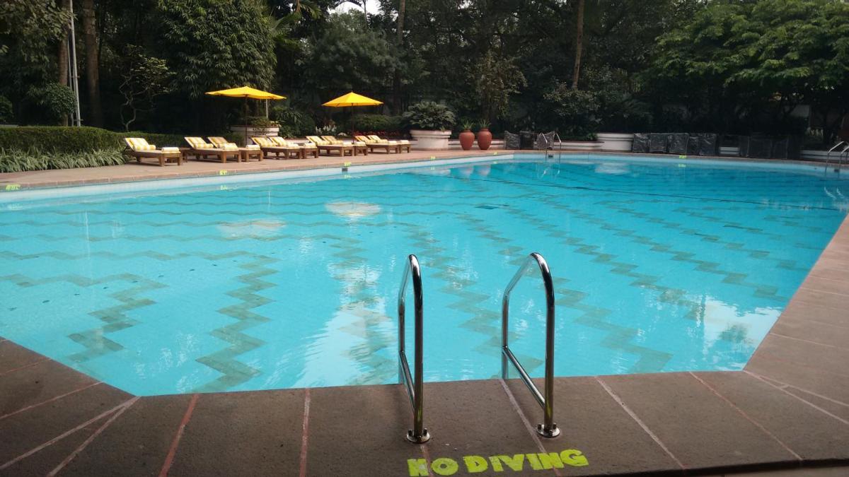 a large swimming pool with blue water at Taj Bengal in Kolkata