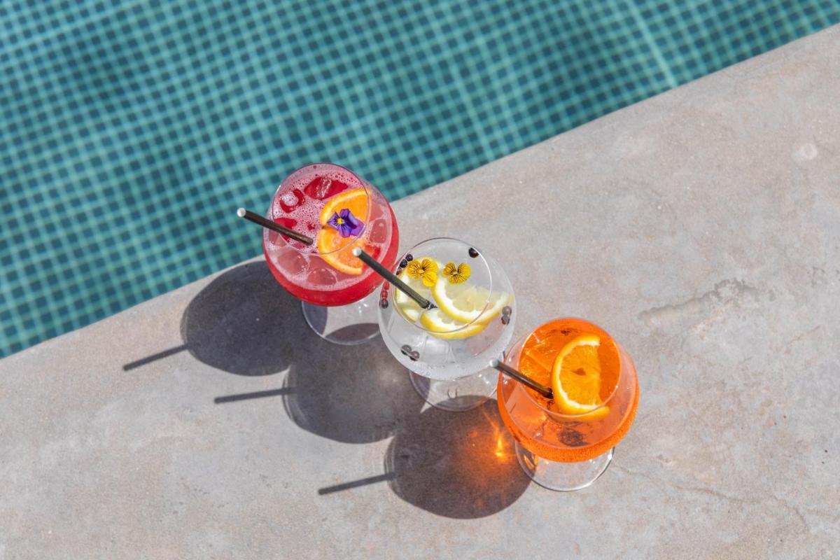 Deux cocktails assis au bord d'une piscine dans l'établissement Grand Hotel Du Golfe - Spa & Restaurant, à Collioure