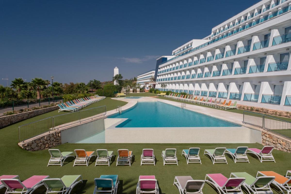 un gran edificio con sillas y piscina en Four Points by Sheraton Costa Blanca Resort, en Benidorm
