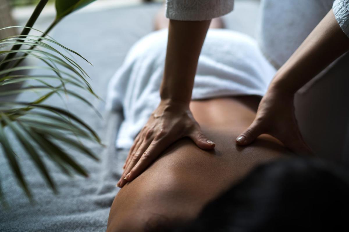 a woman sitting on her back with her hands on her legs at Capri by Fraser China Square, Singapore in Singapore