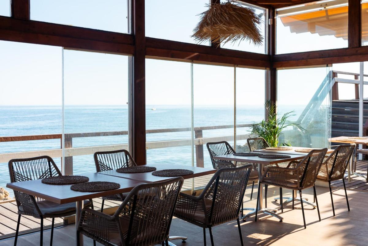 um restaurante com mesas e cadeiras e vista para o oceano em Eden Villas & Apartments em Albufeira mais 128 fotografias