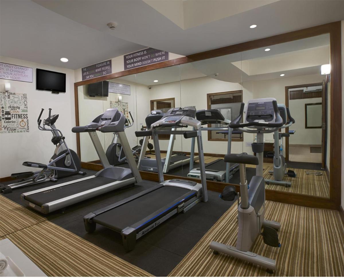a gym with treadmills and ellipticals in a room at Radisson Goa Candolim in Candolim