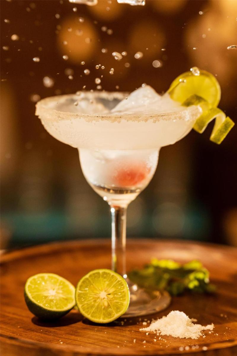 a margarita in a martini glass next to lime slices at Radisson Goa Candolim in Candolim