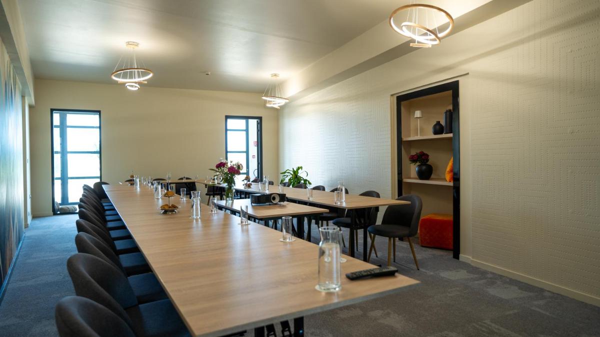 une grande salle de conférence avec une longue table et des chaises dans l'établissement Les Villas du Parc de la Chabotterie, à Saint-Sulpice-le-Verdon