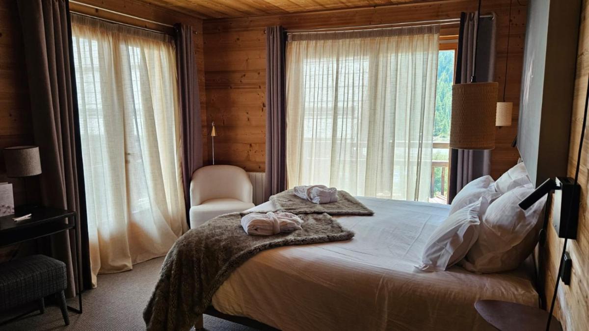 Un ou plusieurs lits dans un hébergement de l'établissement Le Chalet Blanc Hôtel & Spa