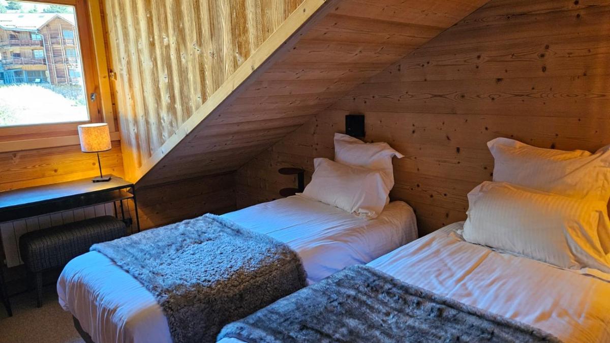 Un ou plusieurs lits dans un hébergement de l'établissement Le Chalet Blanc Hôtel & Spa
