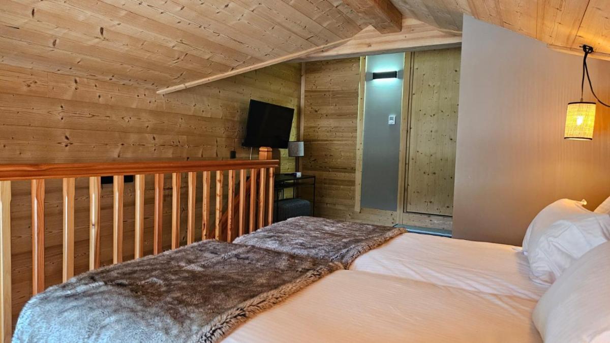 Un ou plusieurs lits dans un hébergement de l'établissement Le Chalet Blanc Hôtel & Spa