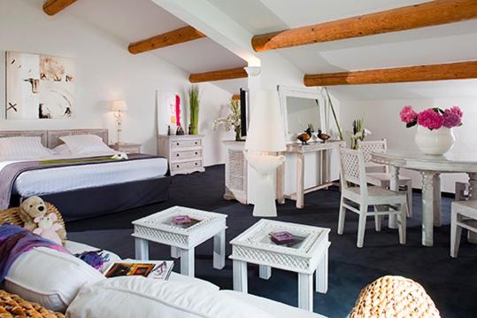 une chambre avec un lit, une table et des chaises dans l'établissement Mangio Fango Hotel et Spa, à Saintes-Maries-de-la-Mer