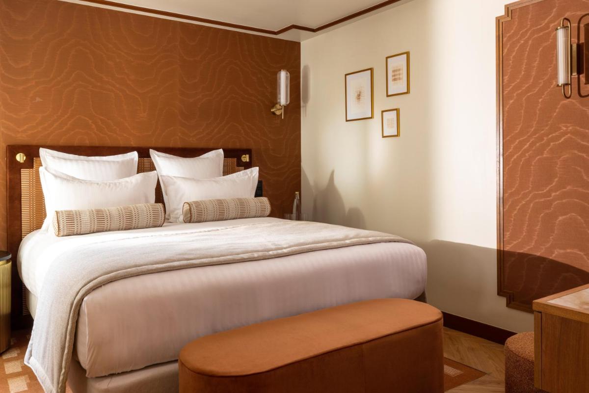 - une chambre avec un grand lit et un mur marron dans l'établissement Hôtel Filigrane & Spa, à Paris