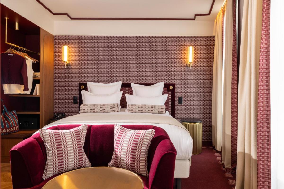 une chambre d'hôtel avec un grand lit et une table dans l'établissement Hôtel Filigrane & Spa, à Paris