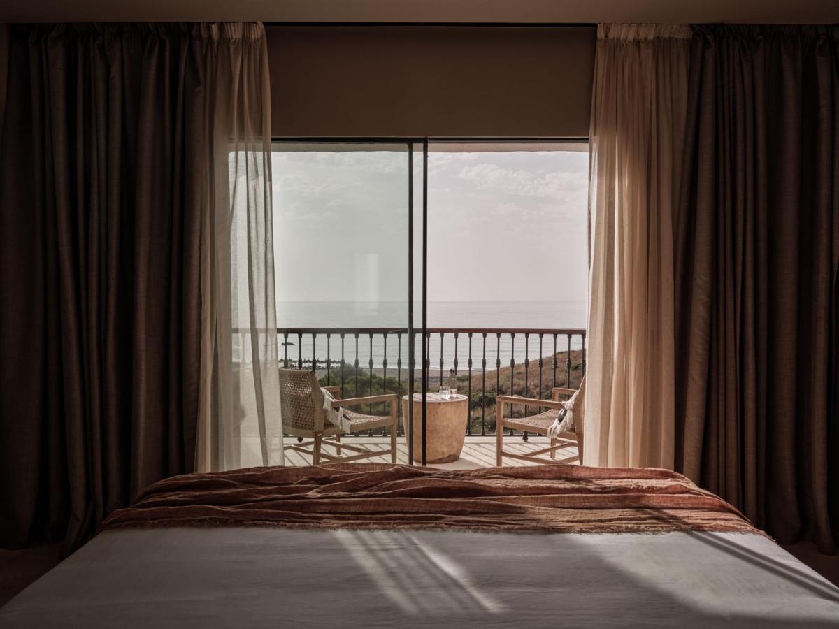 Un dormitorio con una cama y vista al mar. en OKU Andalusia, en Alcaidesa