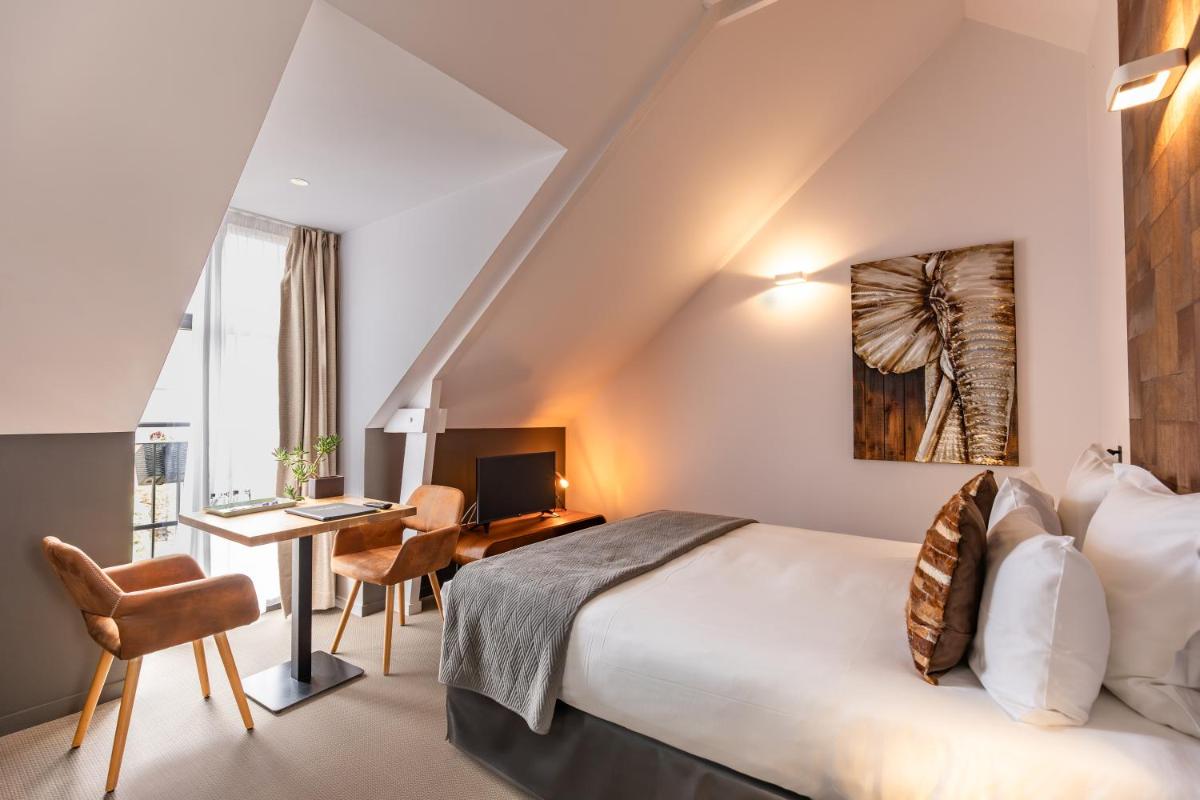 une chambre d'hôtel avec un lit et un bureau avec un ordinateur dans l'établissement Le Manoir de Kerbot, à Sarzeau