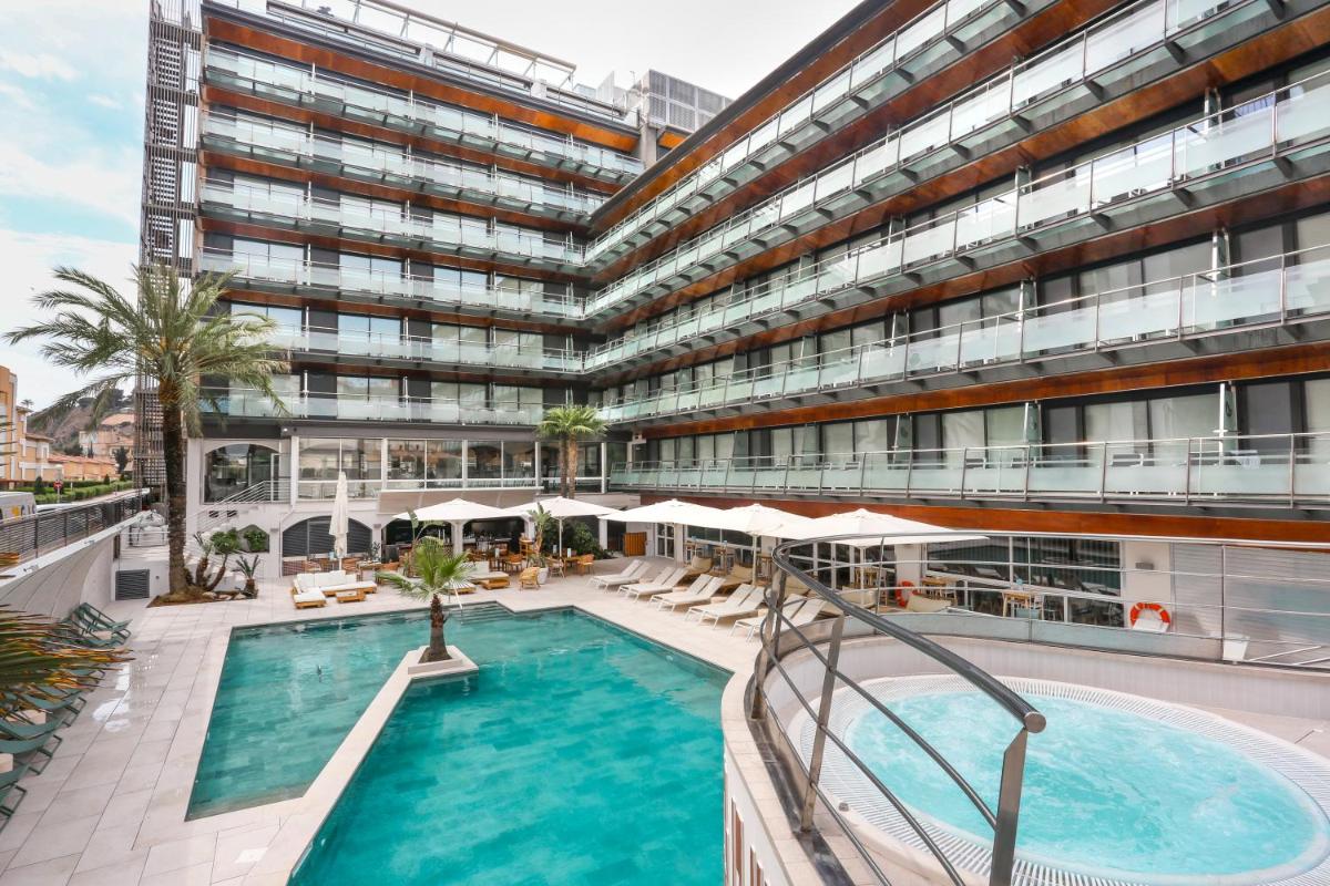 Un gran edificio con una piscina en frente. en KAKTUS Hotel Kaktus Playa - Adults Recommended, en Calella