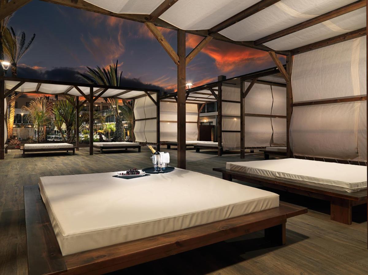 Un dormitorio con dos camas y una mesa. en H10 Ocean Dreams Hotel Boutique - Adults Only, en Corralejo