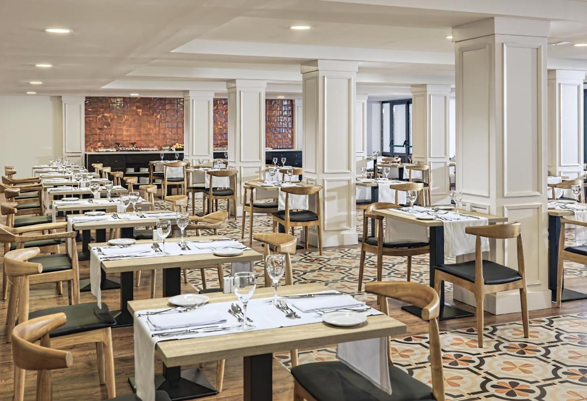 Un restaurante con mesas y sillas en una habitación. en H10 Ocean Dreams Hotel Boutique - Adults Only, en Corralejo