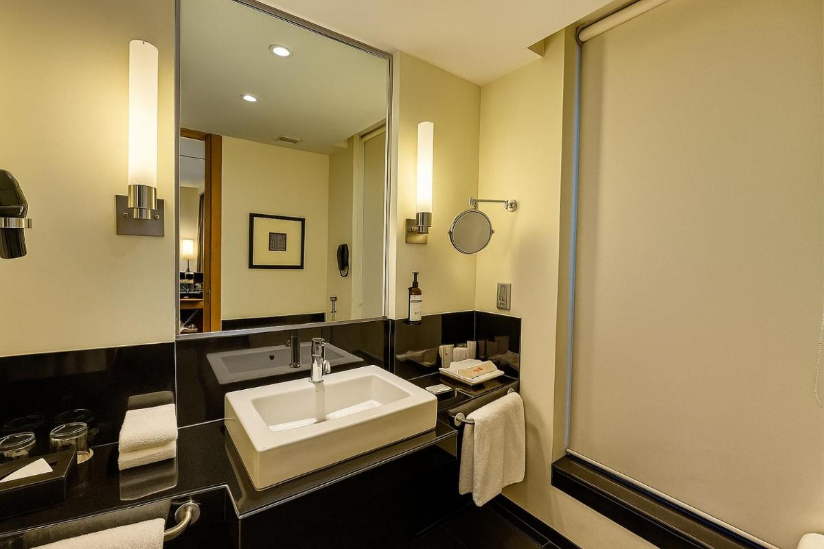 a bathroom with a sink and a large mirror at Hyatt Hyderabad Gachibowli in Hyderabad