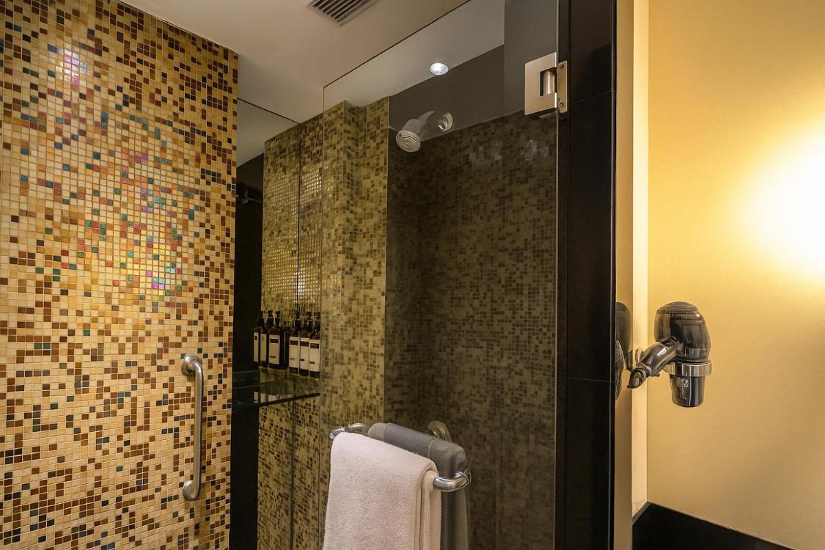 a bathroom with a shower with a tile wall at Hyatt Hyderabad Gachibowli in Hyderabad