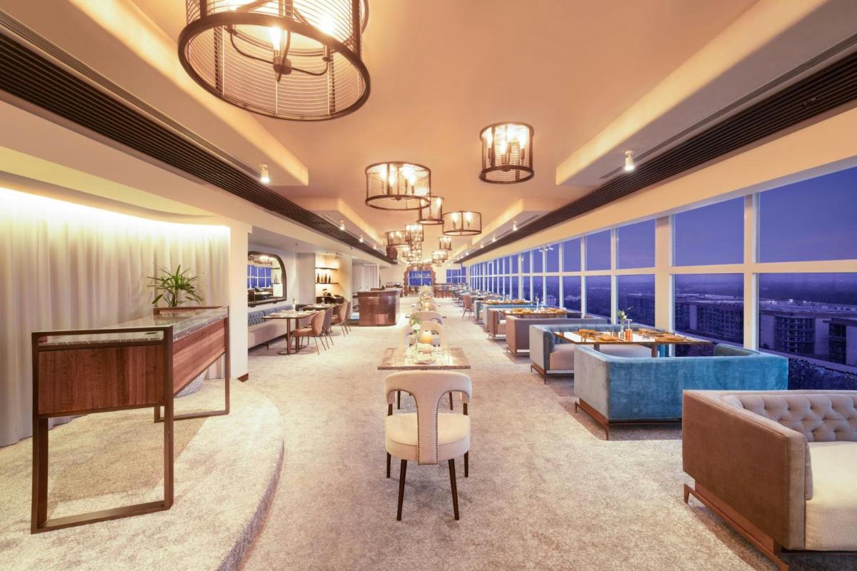 a hotel lobby with couches and tables and windows at Le Meridien New Delhi in New Delhi a hotel lobby with couches and tables and windows at Le Meridien New Delhi in New Delhi